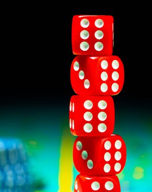 Kumarhanede kumar masasına kırmızı zarlar istiflenir. Poker, kumar ve kumarhane fişlerine karşılık siyah arka plan. Kumar, bahis ve para konsepti.