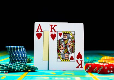 Bir çift papaz ve kumarhanede yeşil oyun masasında kağıt oynayan kupa ası. Siyah arka planda kumar oynamak için kart, fiş ve zarları kapatın. Poker için ayarlandı. Kumarhanede kumar..