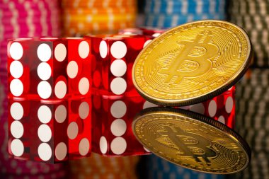 Bitcoin kripto altın sikke, kırmızı zarlar ve yansıtıcı bir yüzey üzerinde kumarhane çipleri. Şans oyunları, poker, kumarhane eğlencesi. Bahisler, risk, başarı ve zenginlik kavramı. Kapat..