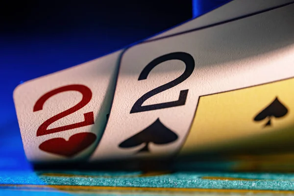 Kumarhanedeki bir oyun masasının mavi arka planında oynayan ikili. Kumar, poker, blackjack, Texas holdem için kağıt oynamayı kesin. Kırmızı ve siyah ikili oyun kartları.