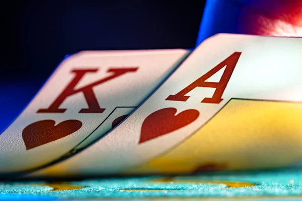 A pair of king and ace of hearts suit playing cards on a blue background of a gaming table in a casino. Close up of playing cards for gambling, poker, blackjack, texas holdem. Gambling in the casino. — Photo