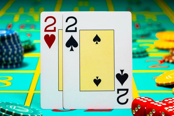 Dvojice dvojic, které hrají karty na zeleném pozadí herního stolu v kasinu. Zblízka hrací karty, žetony a kostky pro hazardní hry, poker, blackjack, Texas Holdem. Hazard v kasinu. — Stock fotografie