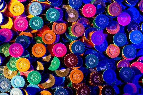 Set of brightly colored poker chips on a gaming table in a casino. Gambling chips in a poker club in blue light. The concept of gambling, betting, money, risk, winning. Close up.