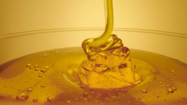 Kalın altın bal bir bardağa akıyor. Taze organik bal pekmezi fışkırıyor. Arıcılığın tatlı ürünü. Sağlıklı tatlı, tatlı yemek, dökülen doğal şurup..