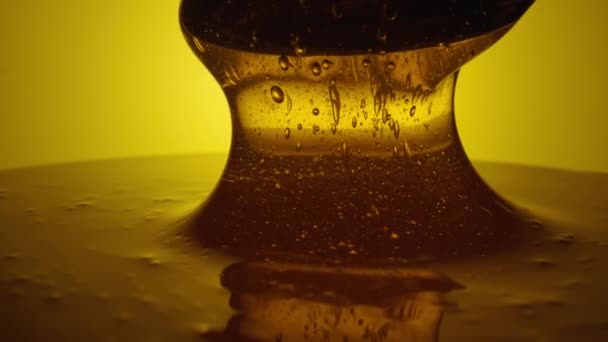 Honey dripping, pouring from spoon. Thick viscous honey molasses dripping. Close up of golden honey liquid, sweet product of beekeeping. Sugar syrup is pouring. Healthy and curative dessert. — Vídeos de Stock