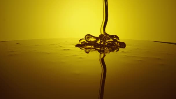 Honung droppar, häller tjock ström på gul bakgrund. Viskösa honungsmelass som flödar. Närbild av gyllene honung vätska, söt produkt av biodling. Sockersirap häller flöde. — Stockvideo