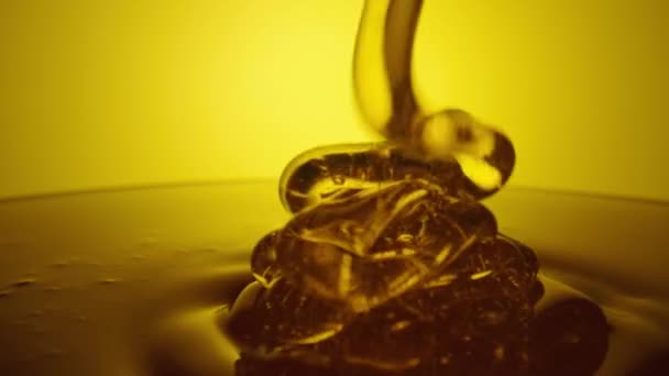 Honey dripping, pouring thick stream on yellow background. Viscous honey molasses flowing. Close up of golden honey liquid, sweet product of beekeeping. Sugar syrup is pouring flow. — Vídeo de stock