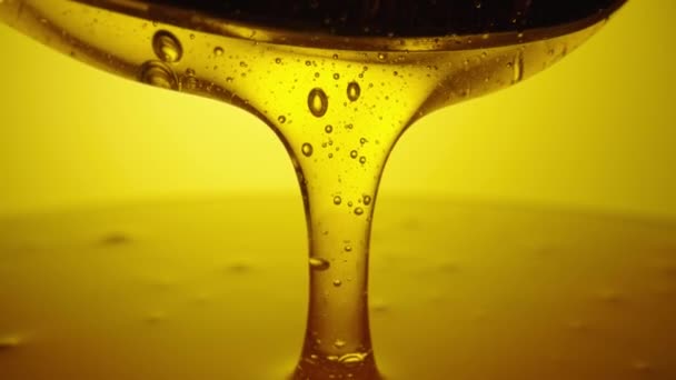 Honey dripping, pouring from spoon. Thick viscous honey molasses dripping. Close up of golden honey liquid, sweet product of beekeeping. Sugar syrup is pouring. Healthy and curative dessert. — Vídeo de Stock