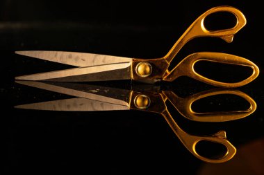Siyah arka planda altın saplı terzi makası. Dikiş dikmek, terzilik, kumaş kesmek, terzilik. Atölyede el yapımı ya da el işi malzemesi.