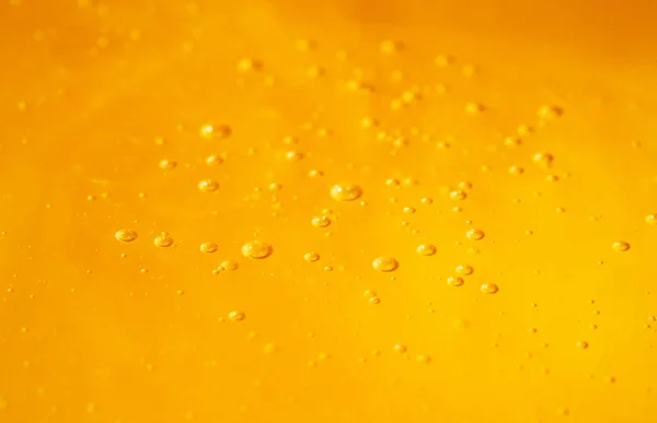 Golden organic honey with bubbles. A splash with sweet syrup, molasses or yellow nectar. Close up of honey texture. Dessert, sweet food, bee product. – stockfoto