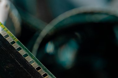 Çizik ve çiziklerle dolu eski analog filmlerden oluşan siyah kıvrımlı şeritler. Fotoğraf ya da film için video ya da film yakın çekim. Retro sinematografi, fotoğrafçılık, fotografik hafıza kavramı. Medya