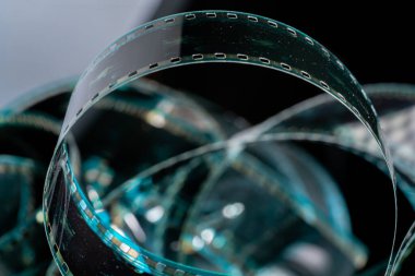 Çizik ve çiziklerle dolu eski analog filmlerden oluşan siyah kıvrımlı şeritler. Fotoğraf ya da film için video ya da film yakın çekim. Retro sinematografi, fotoğrafçılık, fotografik hafıza kavramı. Medya