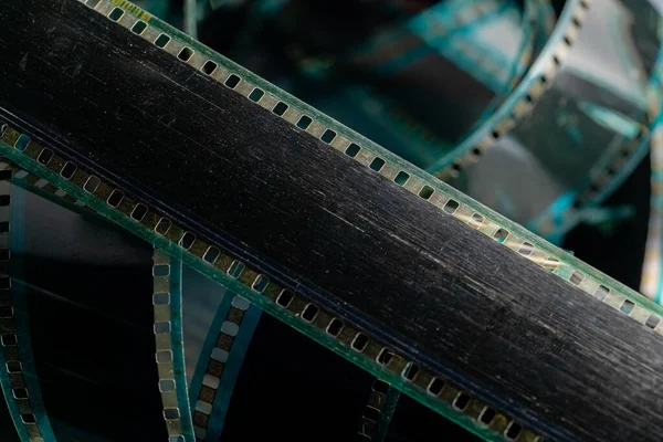 Black swirling strips of old analog film with scratches and scuffs. Photo or video film for films or pictures close up. The concept of retro cinematography, photography, photographic memories. Media
