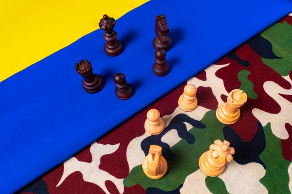 ウクライナの黄色の青い旗と軍の制服の茶色の緑の迷彩生地にチェス 戦争戦略 エスカレーション ウクライナでのロシア軍の特殊作戦の概念 軍事カーキ ユニフォーム — ストック写真