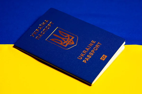 ウクライナの青い黄色の旗の上にウクライナの生体パスポート 人の識別のId文書 ウクライナの市民権 戦争による難民の概念2022 閉じろ — ストック写真