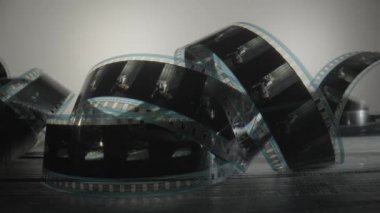 Eski siyah beyaz eski bir film kasedini tasvir ediyor. Retro film şeridini ya da fotoğraf negatifini kapat. Çekim süreci için endüstri sembolü, retro sinematografi, fotoğrafçılık, fotoğraf