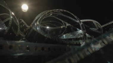 Spiral siyah film şeridi ya da fotoğraf negatifi. Fotoğraf ya da video kamera için eski siyah beyaz film şeritlerini analiz et. Seçici olarak film deliklerine odaklan. Sinematografi konsepti