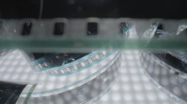 Resimli, klasik, negatif, siyah beyaz film. Bukleli bantlı filme odaklan. Eski bir sinema filmi. Siyah film kapanıyor. Çekim süreci için sanayi sembolü, retro sinematografi