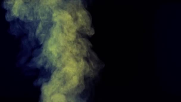 黄色の青色の光に照らされた蒸気の雲が立ち上がる 水分粒子の閉じ込め 蒸気が蒸発します 孤立した黒の背景に上昇霧 水蒸気が上昇して空気中に浮かぶ — ストック動画
