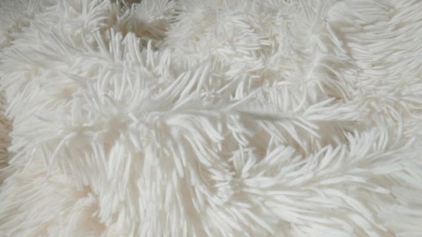 人工的なシャギー白色合成繊維の繊維 フェイクファーの服の表面 フェイクファー素材ブランケット シャギーホワイトアクリル髪 ふわふわのフリース生地の質感が非常にクローズアップされています — ストック動画