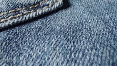 Makro kot pantolon kumaşı. Giysinin yapısı, tekstil malzemesi, pamuktan kumaş. Kumaş kumaş dokusuna çok yakın. Sarı ipliklerle dikilmiş dikişler