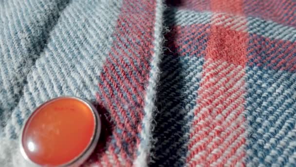 マクロに赤いボタンを持つ暖かいウールのプレイシャツからの背景 繊維材料 ウールや綿で作られた柔らかい生地の構造 赤のチェックの布 服の質感 — ストック動画