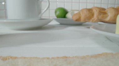 Bir parça taze ekmek ekmeğine çikolata ezmesi süren bir bıçak. Kakao ezmeli bir sandviçe yaklaş. Sabahları mutfakta lezzetli bir kahvaltı hazırlıyorum. Tatlı tatlı, lezzetli.