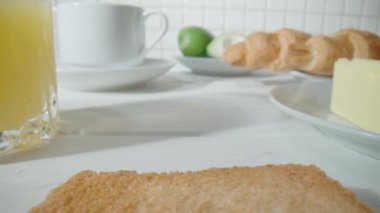 Kahverengi çıtır kıtır ekmek ile bir dilim kızarmış ekmek. Kahvaltıda tost. Mutfak masasında taze kızarmış ekmek var. Yakın çekim. Sandviçler için ekmek ürünleri, fast food