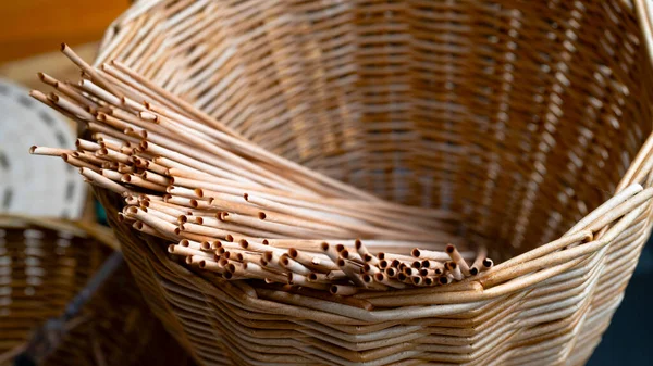 Handmade basket made of brown paper tubes. Rustic basket with rolled paper tubes. Texture of a braided pattern from eco vines. Basket weaving background, striped binding. Creativity, art, handwork