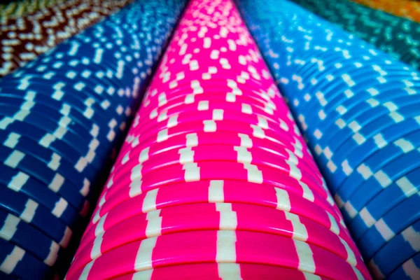 Vertical rows of colored casino chips. Set of blue and pink gambling chips. The concept of a casino, playing poker, roulette or craps. Bet, money, win. Extra close up