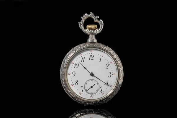 Silver mechanical antique pocket watch on black isolated background. Retro pocketwatch with second, minute and hour hand. Old round clock with dial for gentleman. Vintage timepiece. Symbol of time