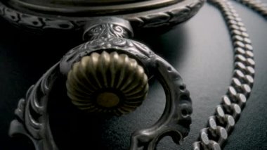 Gümüş zincir ve gri arka planda antika bir cep saatinin iç çalışma mekanizması. Saat mekanizması makro döngü. Vidalar, hareket eden yay, dönen dişliler ve eski bir saatin dişlileri.