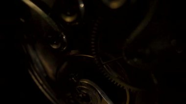 Parçalanmış, saat gibi çalışan altın bir cep saati. Çalışan saat mekanizması döner yay, dişliler, dişliler ve dişli tekerlekler. Hareketli bir saatin içeriden görüntüsü.
