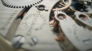 Internal vintage clockwork mechanism macro. Rotating gold gears, metal gearing, wheels with tootheds. Disassembled watch with screws, cogwheels and winding spring. Open working clockwork and fragments
