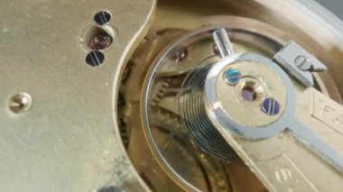 İç klasik saat mekanizması makrosu. Dönen altın dişliler, metal dişliler, dişlilerin tekerlekleri. Vidaları, çarkları ve yayı olan parçalanmış bir saat. Çalışan saat ve parçalarını aç