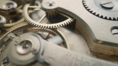Çalışan cep saati mekanizmasının içinde metal dişlileri hareket ettiriyor. Çalışan saat mekanizması döner yay, dişliler, dişliler ve dişli tekerlekler. Hareketli bir saatin içeriden görünüşü. Dahili makro çekim