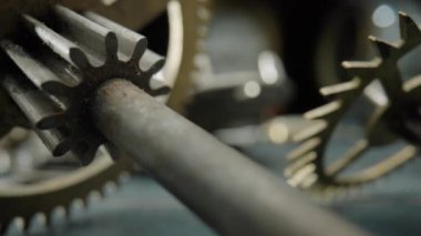 Eski bir saatin kirli, tozlu iç parçaları. Saat mekanizması, dişliler, dişliler, dişliler ve bulanık arka planda yay. Eski bir saatin parçalanmış saat mekanizması. Atölyedeki saat parçaları