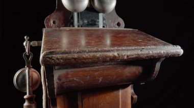 Wooden brown antique telephone apparatus with two metal hemispheres for signaling call. Old school bell. Retro phone with aged handset and mechanism for loud chime. Vintage shabby phone on isolated