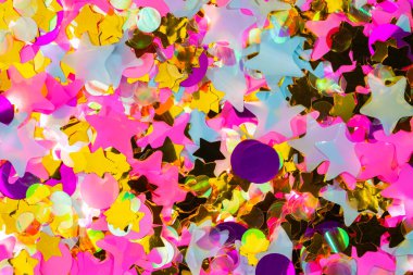 Bright colorful pink, white, purple and gold stars and circles. Pattern from sequins, tinsel, confetti for new year, holiday, birthday. Festive background for party, carnival, celebrate. Decor