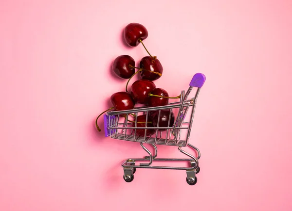 Ripe Red Sweet Cherries Small Shopping Cart Pink Background Juicy — Zdjęcie stockowe