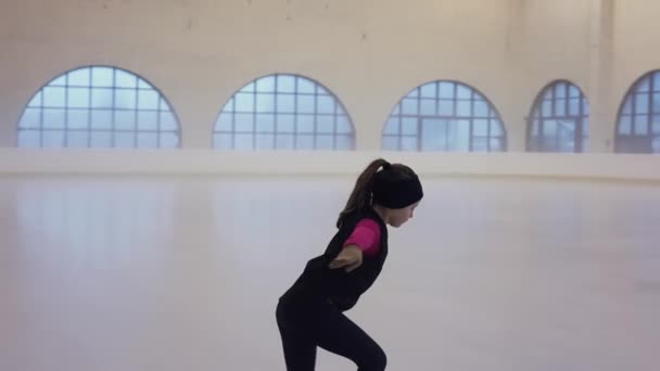 氷の上に行く前に彼女のフィギュアスケートの生徒に助言を与えるプロの女性トレーナー 大きな窓を背景に氷のアリーナに沿って自信を持ってスライド女の子 — ストック動画