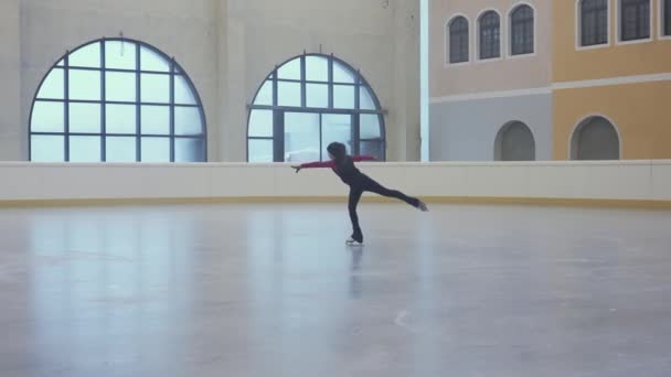 小さな女の子は専門的にリンク上の氷の上にスライドします 女子フィギュアスケートコーチは彼女の学生を賞賛する 明るい照明の氷のアリーナでのフィギュアスケートのトレーニング スキル開発 スローモーション — ストック動画