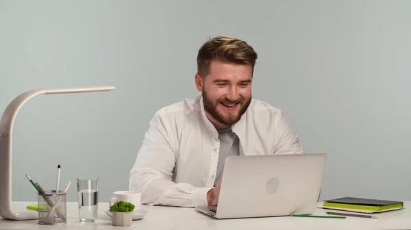 Smiling bearded man office worker holds conference meeting on laptop computer, sitting in a home office. Male manager doing professional webcam online chat. Live digital training, elearning concept