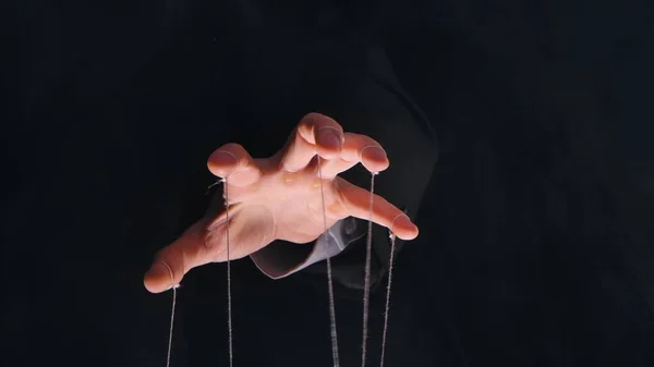 Man hands with threads or strings on fingers. Manipulation in business, control of managers, dominance of boss over people, power concept. Close up dictators hand holds strings for manipulation on