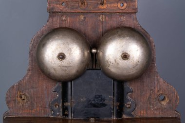 Tahta kahverengi antika cihaz. İki metal yarı küresi var. Sinyal vermek için, vidalarla vidalanmış. Eski usul zil. Gürültülü çan için Retro telefon mekanizması. Grey 'den klasik yüksek sesli telefon çağrısı