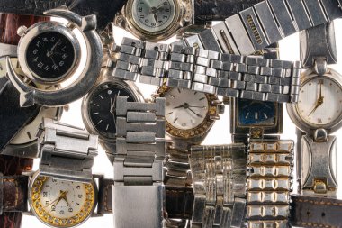 Metal bileklikleri ve deri saatleri olan bir kol saati. Yapay elmaslı kadın vintage saatleri. Siyah ve gümüş kadranlı Retro erkek kol saati. Beyazın üstüne klasik kol saatini kapat
