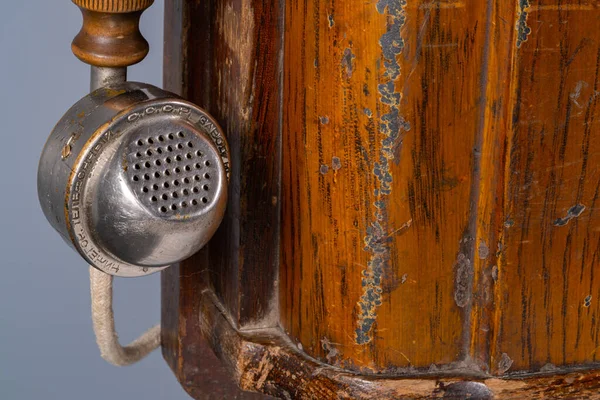 Kahverengi ahşap kutu, ahşap ahşap ahşap bir telefon seti. Gri arka planda eski püskü bir telefon. Telekomünikasyon ve sohbet için antika, yuvarlak cep telefonu