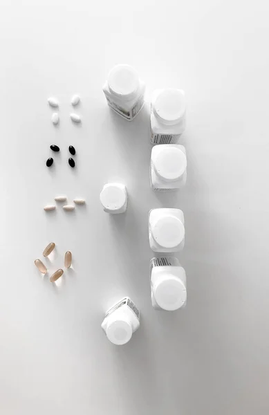 Gyönyörű vitaminos dobozok egy fehér asztalon. Vitaminok a fehér asztalon. Fehér asztalon lévő tabletták. — Stock Fotó