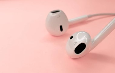 Kulaklık güzel pembe bir arka planda yatıyor. Asgari arkaplan.