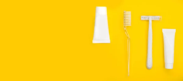 Szczoteczka do zębów, brzytwa, pasta do zębów, minimalistyczne żółte tło. — Zdjęcie stockowe